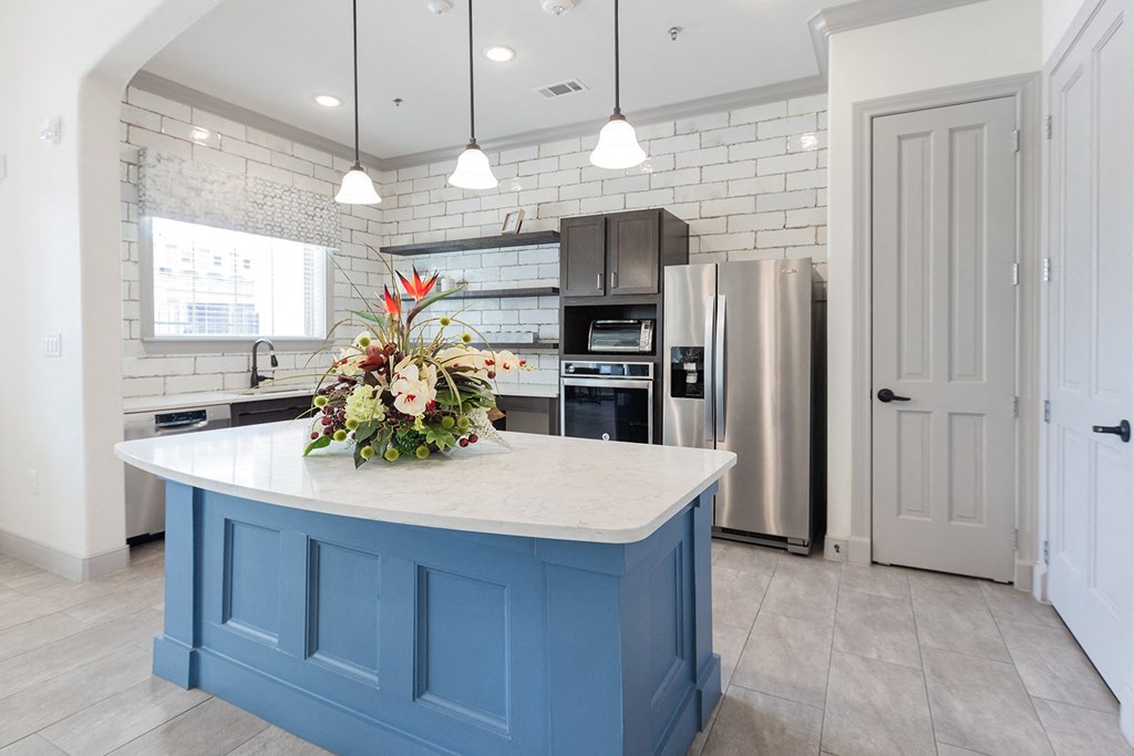 a kitchen with a blue island and a stainless steel refrigerator