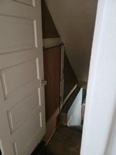 a white door leading into a small room with stairs