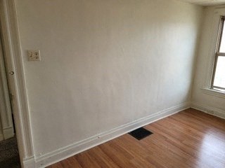 an empty room with white walls and a wood floor