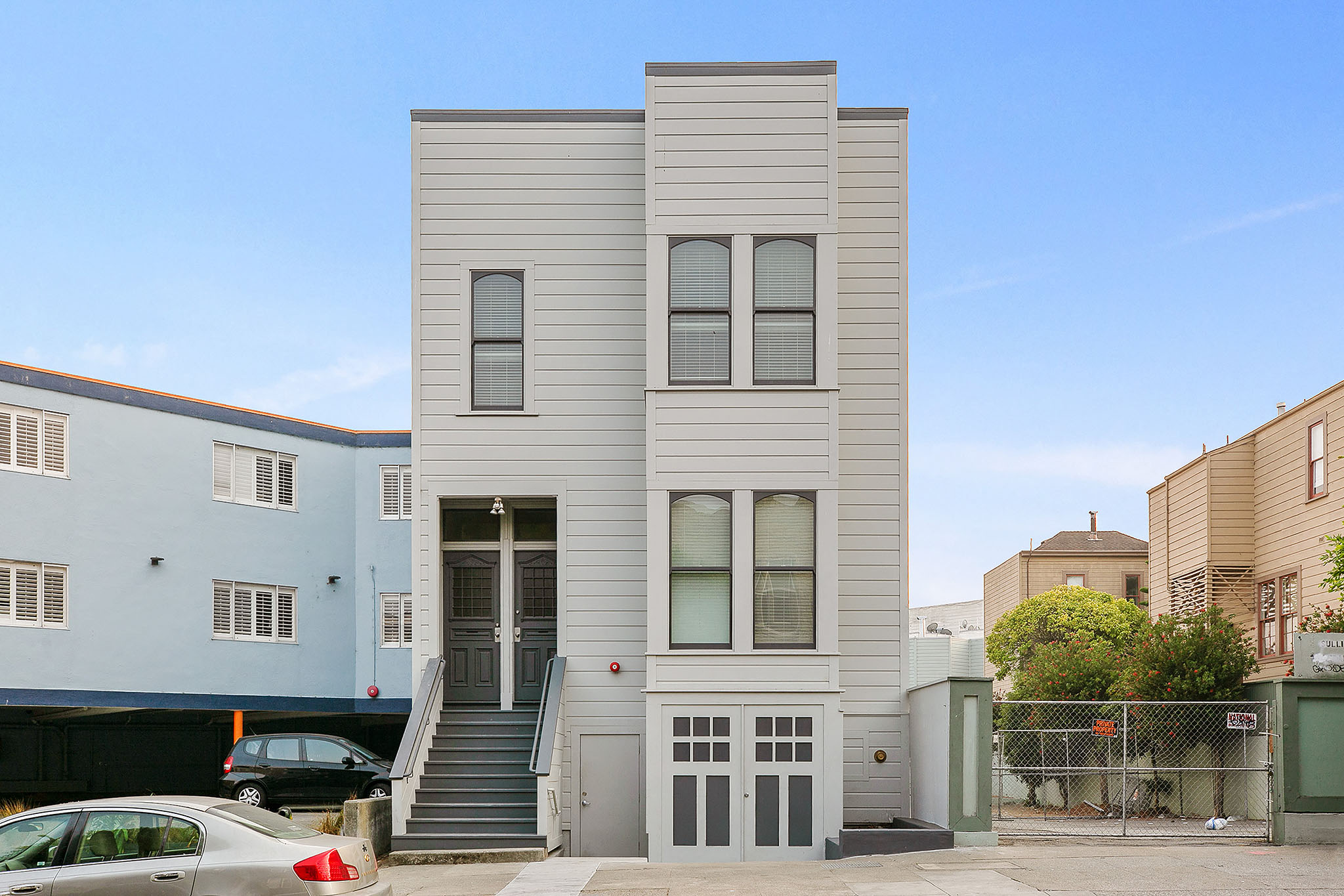 the front of a house with stairs and a car in front of it