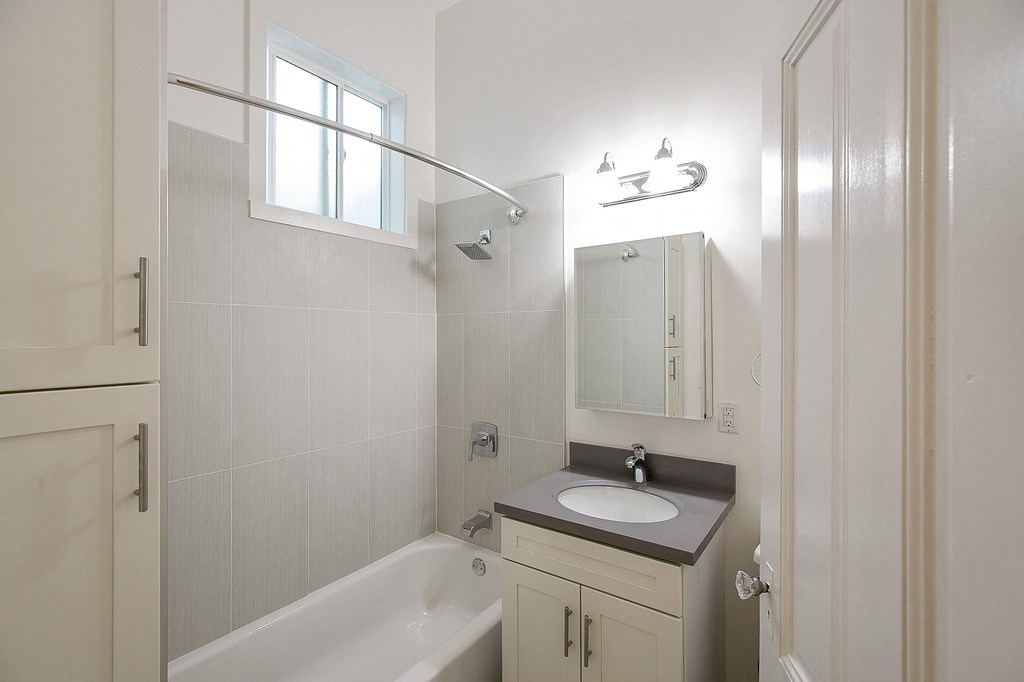 a bathroom with a sink and a shower and a mirror