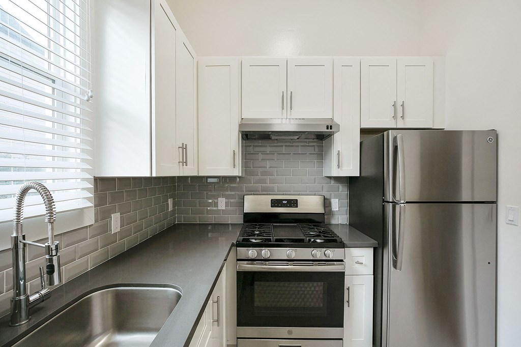 a kitchen with stainless steel appliances and white cabinets
