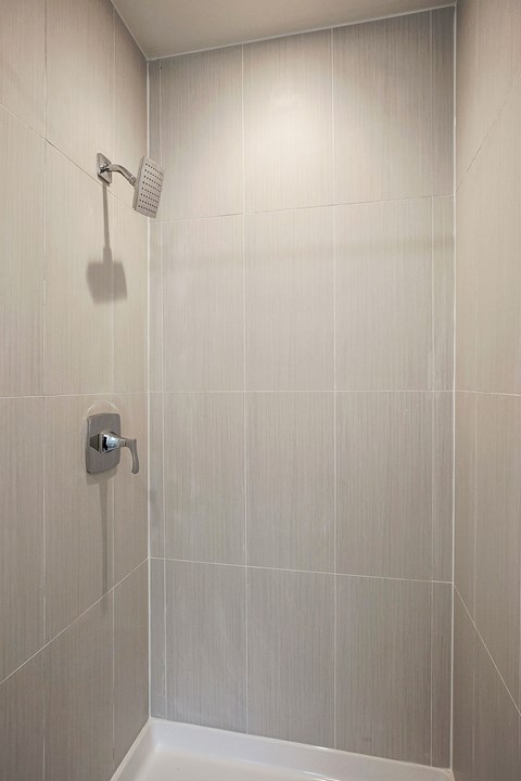 a white tiled shower in a bathroom