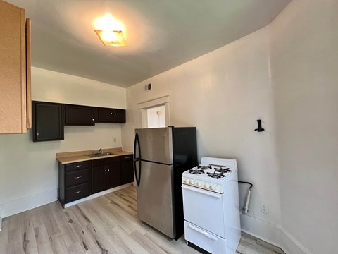 A kitchen with a stove and refrigerator.