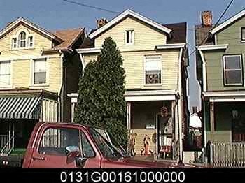 a red car parked in front of a yellow house