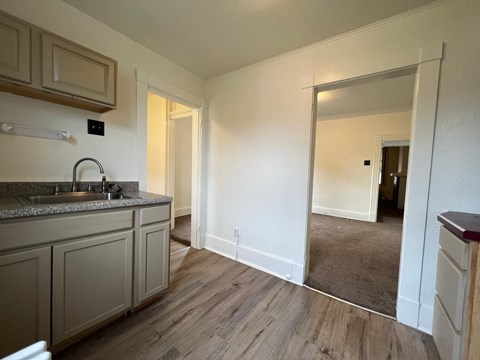 a kitchen with a sink and a mirror in a house