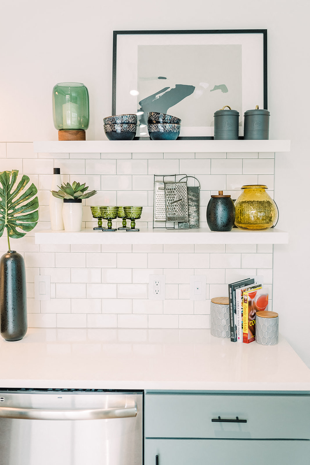 a kitchen with white tiles and shelves and a mirror