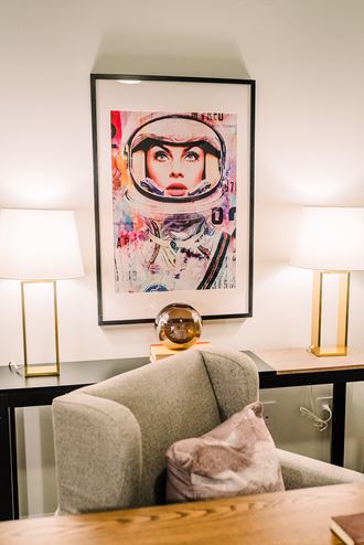 a living room with a chair and a painting on the wall