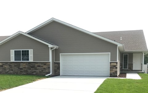 A house with a grey roof and a white garage door.