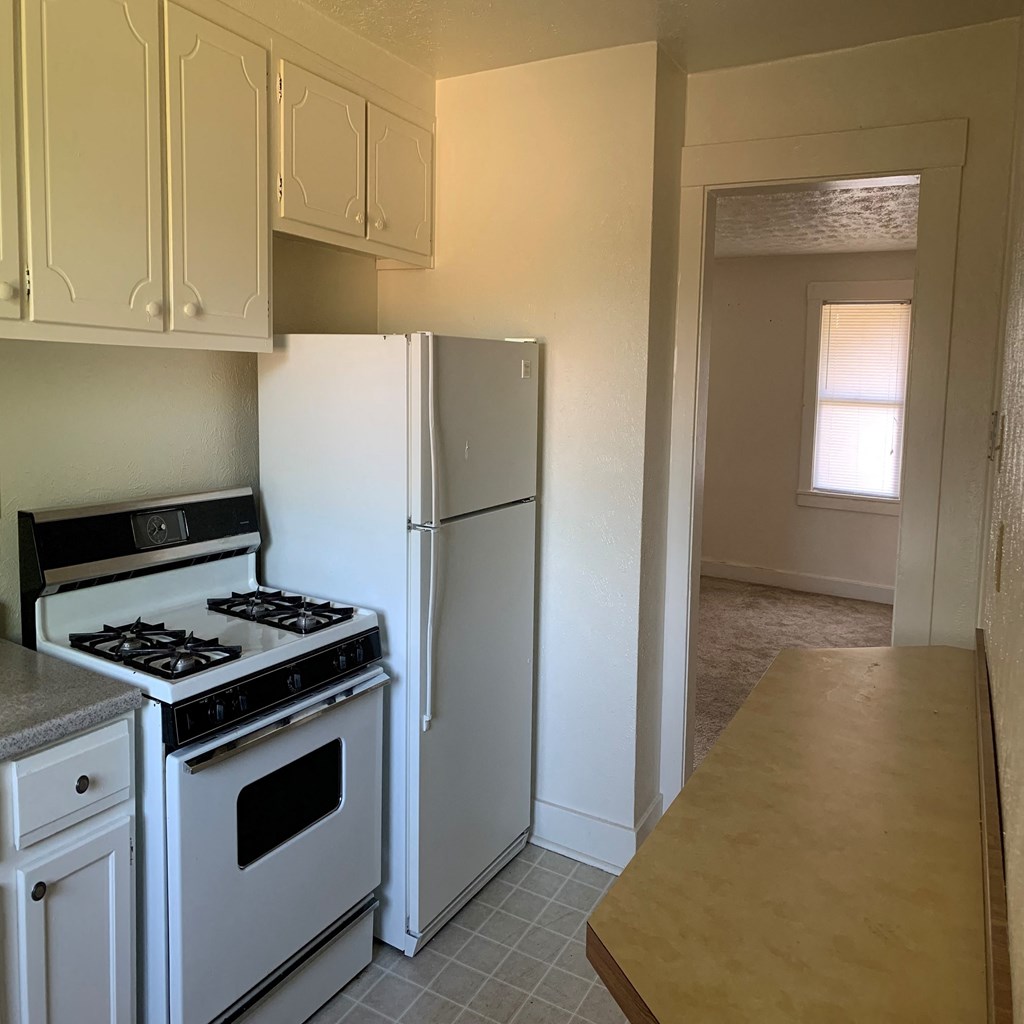 a kitchen with white appliances and a refrigerator