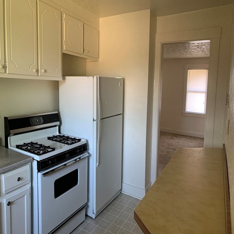 a kitchen with white appliances and a refrigerator