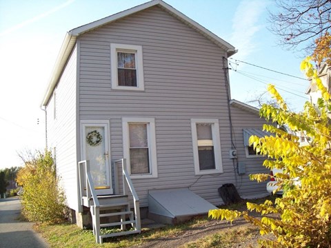the front of a house with a porch and stairs