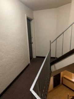 a hallway with a staircase and a door