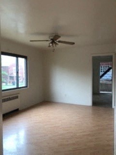 an empty living room with a ceiling fan