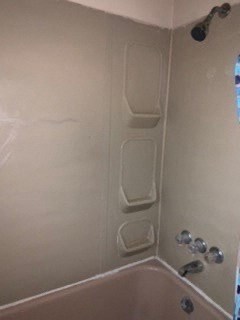 a bathroom with a shower and a tub and a window