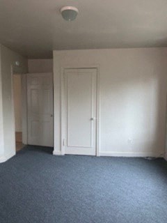 an empty room with white walls and a white door