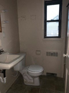 a bathroom with a toilet and a sink and a window