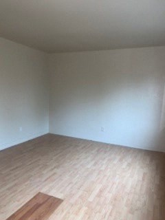 an empty room with wooden floors and white walls