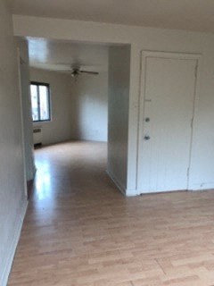 an empty living room with white walls and a wood floor