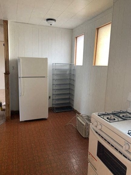 A kitchen with a white fridge, a white stove and a white oven.