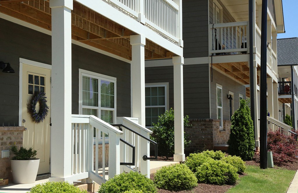 a row of houses with a porch and a porch swing