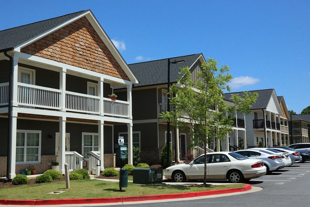 a row of apartments with cars parked in front of them