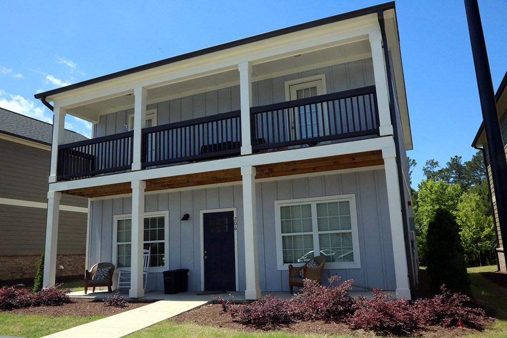 the front of a white house with a balcony