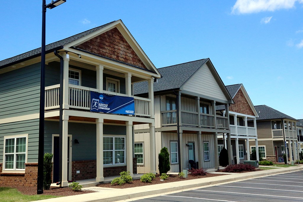 a row of townhomes with a porch and a blue sign
