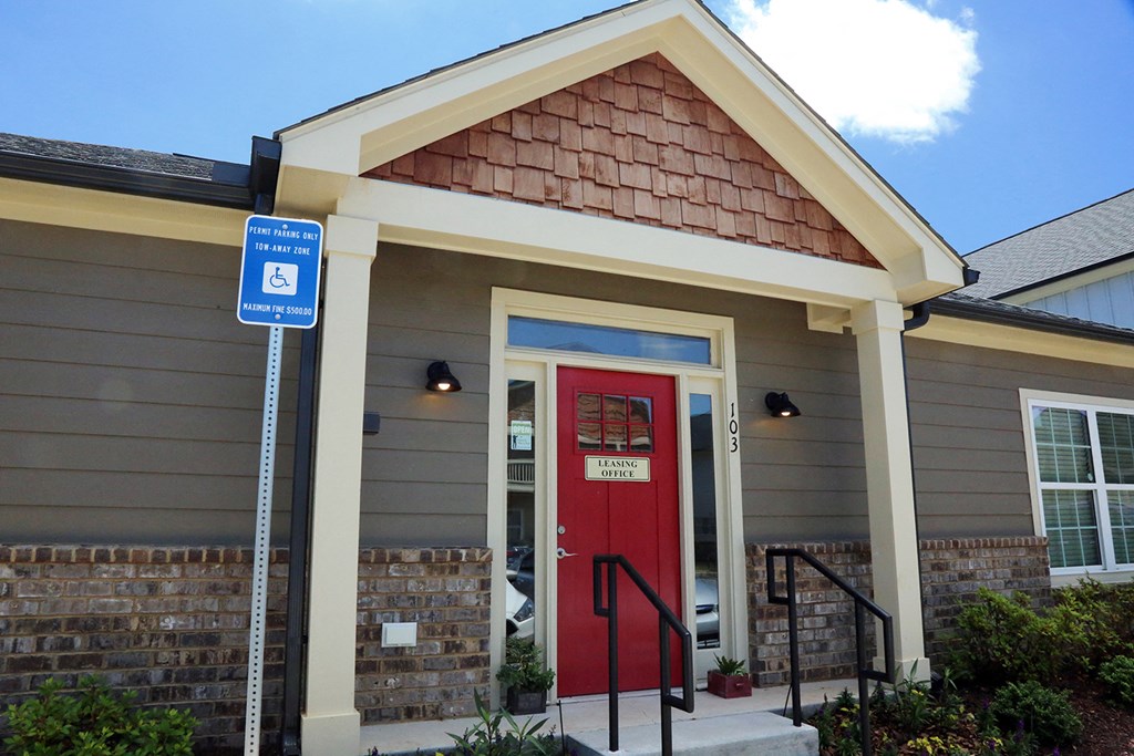 a house with a red door and a handicapped sign in front of it