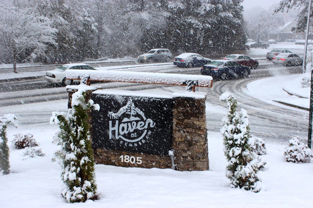 a sign sits in the snow next to a road