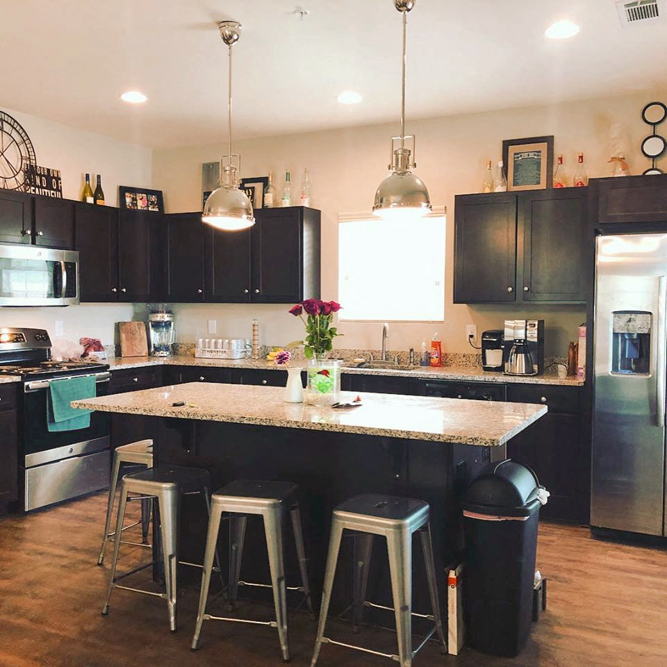 a large kitchen with black cabinets and a counter top