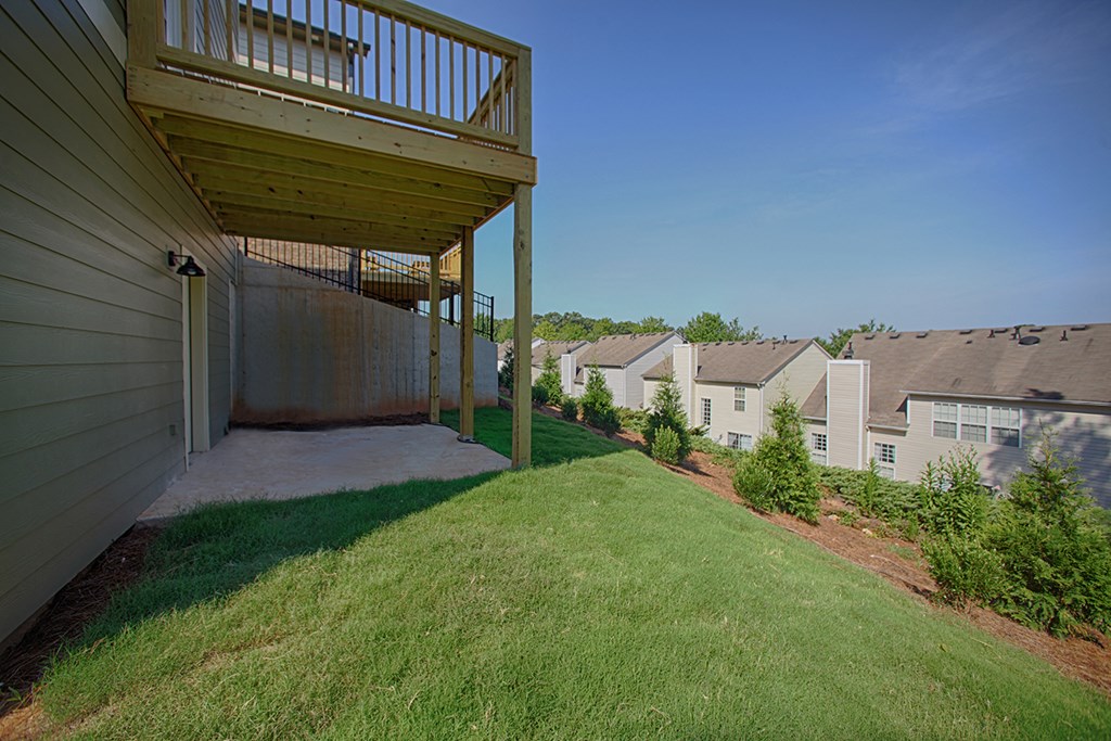 the backyard of a house with a deck and a yard