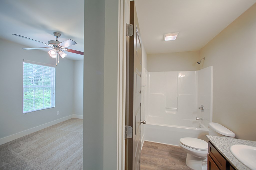 the view of a bathroom with a shower toilet and sink from the doorway