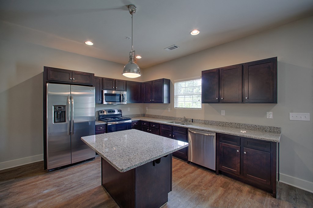 an updated kitchen with stainless steel appliances and granite counter tops