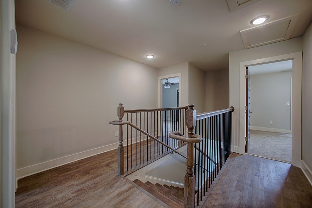 the descent into the basement of a home with stairs and a door to a hallway