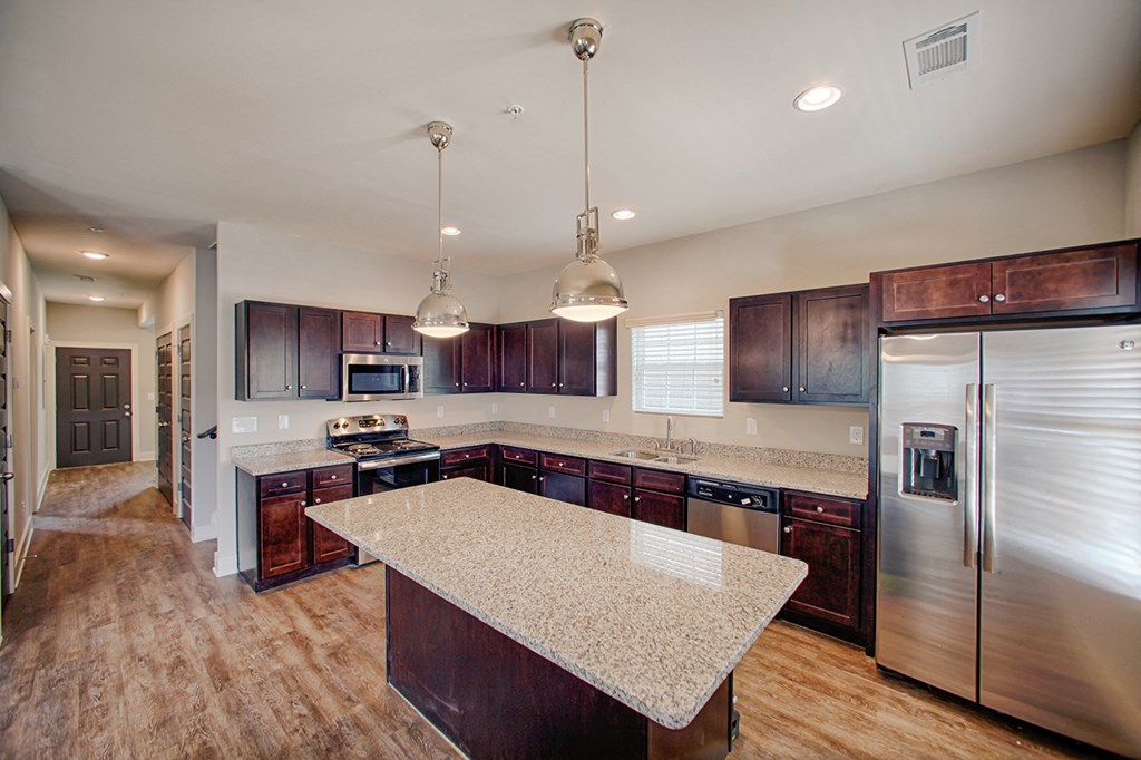 a kitchen with stainless steel appliances and a marble counter top