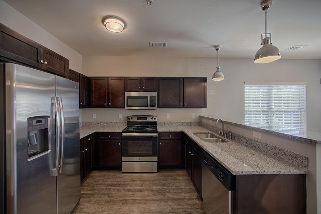 a kitchen with granite counter tops and stainless steel appliances