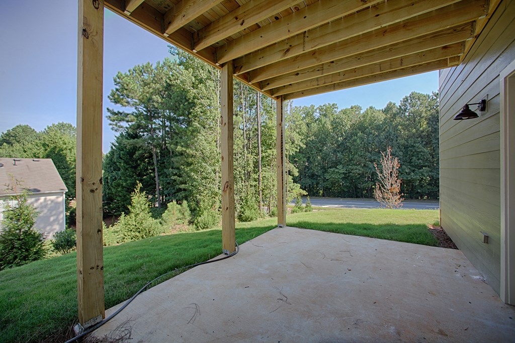 a patio with a view of a yard and trees