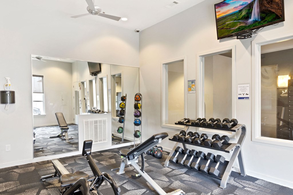 the gym with weights and mirrors at the preserve apartments