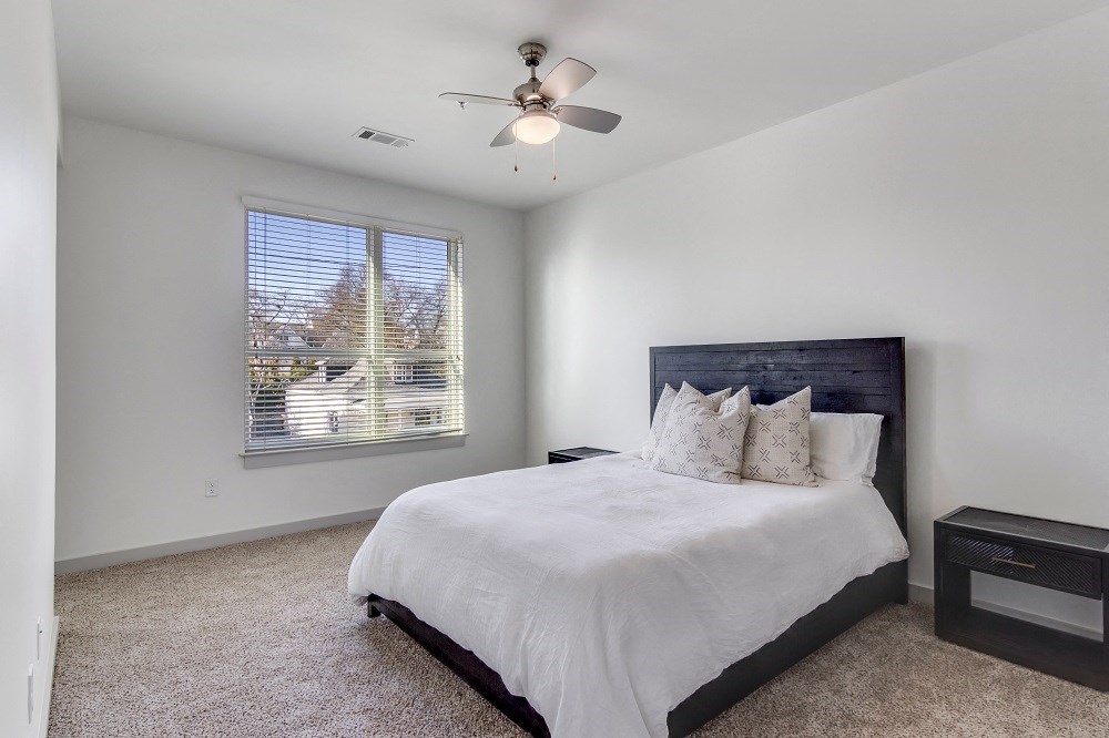 a bedroom with a large bed and a ceiling fan