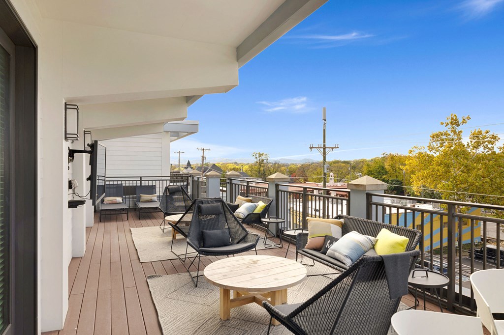 a balcony with patio furniture and a view of the city