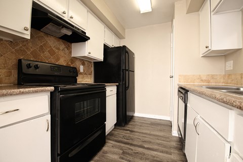 a kitchen with black appliances and white cabinets