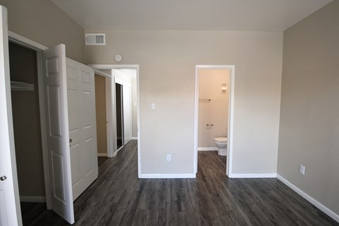 a bedroom and a bathroom with a closet and a toilet