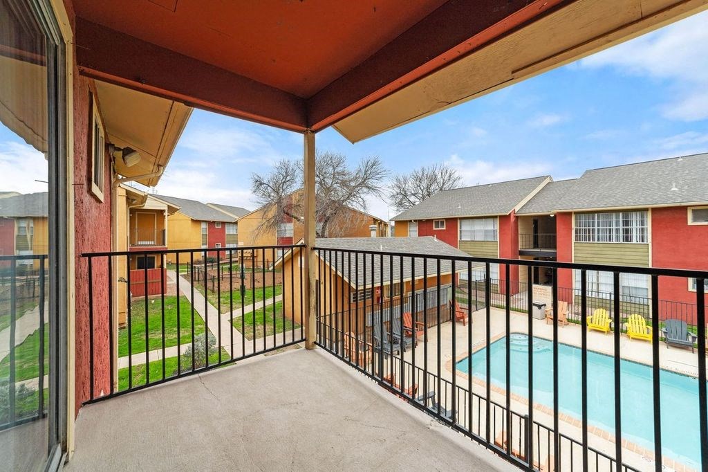 the view of a pool from the balcony of an apartment building