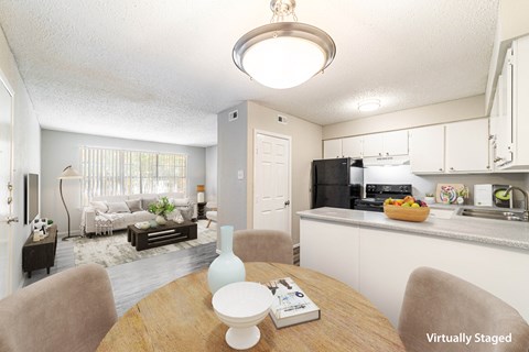 a living room and kitchen with a table and chairs