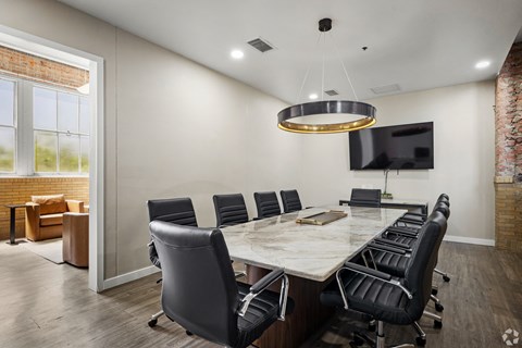 A conference room with a long table and chairs.