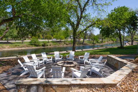 A table surrounded by chairs in a garden.