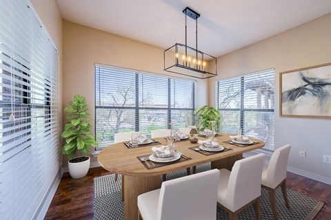 A dining room with a wooden table and white chairs.
