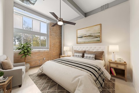 A bedroom with a large bed and a ceiling fan.