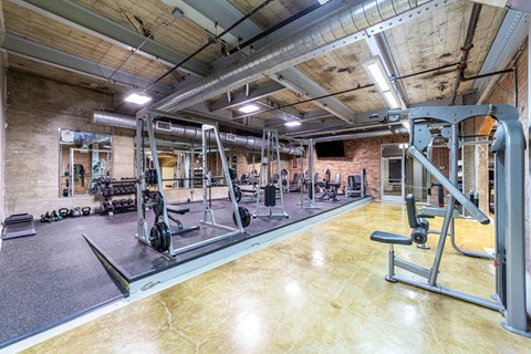 A gym with a variety of equipment including weights and machines.